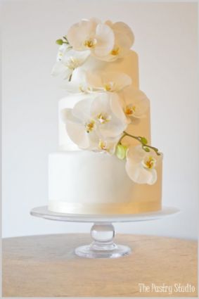White Shimmery Wedding Cake Adorned with Orchids – created by The Pastry Studio